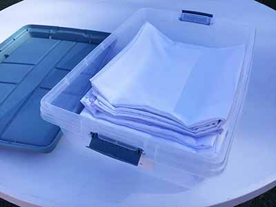 60 inch x 126 inch white rectangle tablecloths pulled directly from storage tote and put onto eight-foot rectangle tables