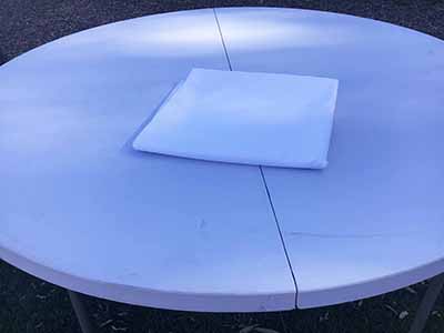 60 inch x 126 inch white rectangle tablecloths pulled directly from storage tote and put onto eight-foot rectangle tables