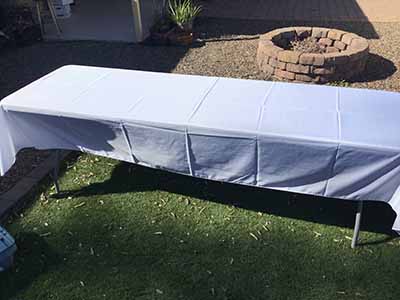 60 inch x 126 inch white rectangle tablecloths pulled directly from storage tote and put onto eight-foot rectangle tables