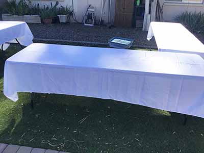60 inch x 126 inch white rectangle tablecloths pulled directly from storage tote and put onto eight-foot rectangle tables