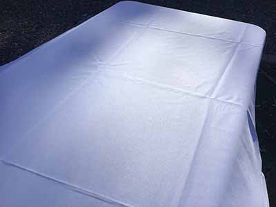 60 inch x 126 inch white rectangle tablecloths pulled directly from storage tote and put onto eight-foot rectangle tables