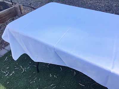 60 inch x 126 inch white rectangle tablecloths pulled directly from storage tote and put onto eight-foot rectangle tables