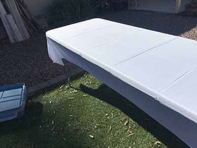 60 inch x 126 inch white rectangle tablecloths pulled directly from storage tote and put onto eight-foot rectangle tables